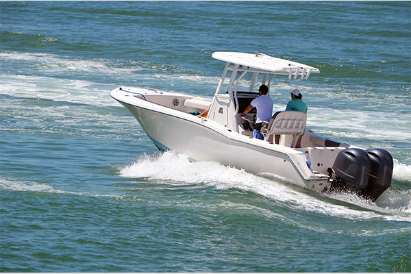 People riding a white speedboat across open water.