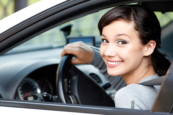 Happy Driver Smiling woman sitting in the driver’s seat of a car.