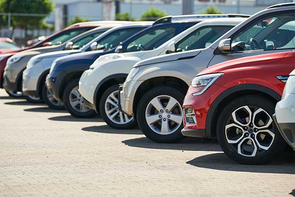 Cars Row of parked cars lined up in a dealership lot.