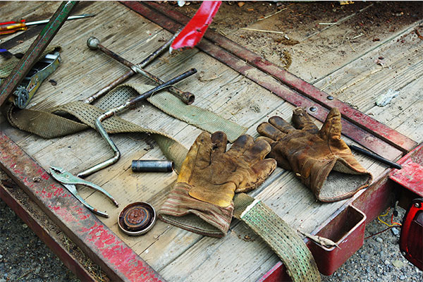 Work Tools Assorted tools and gloves placed on a wooden workbench.