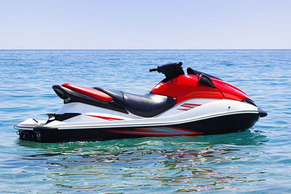 A red and white jet ski floating on calm blue water.