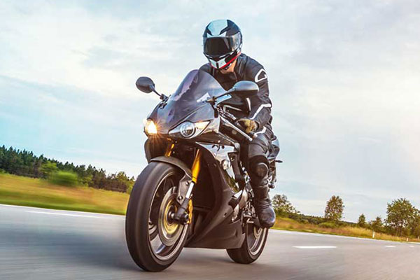A person riding a sport motorcycle on an open road.